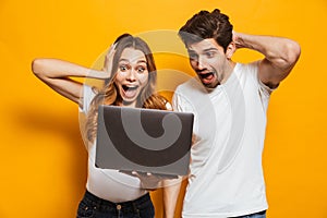 Portrait of excited couple man and woman screaming and grabbing