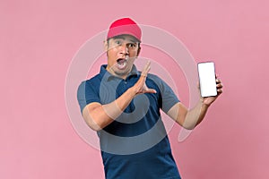 Portrait of a excited happy young delivery man showing display of mobile phone