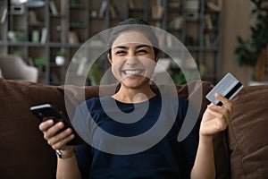 Portrait of excited Indian woman shopping on cellphone