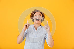 Portrait of excited joyful man 20s laughing and pointing fingers