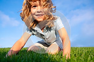 Portrait of a excited little boy in the park. Funny little boy playing in garden backyard laughing and having fun