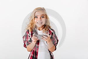 Portrait of an excited little girl holding mobile phone