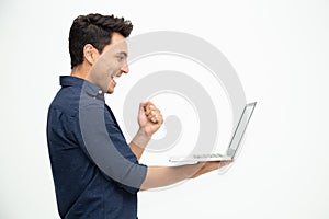 Portrait of an excited man holding laptop computer