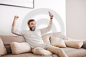 Portrait of an excited man holding remote control