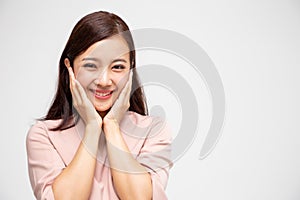 Portrait of excited screaming young asian woman standing in pink dress isolated over white background.