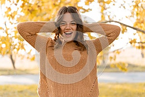 Portrait of excited screaming young woman standing in autumn park. Wow and surprised concept.