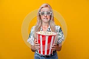 Portrait of excited woman with straight hairstyle in 3d glasses hold popcorn watch thriller bite lips isolated on yellow