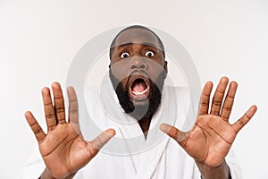 Portrait of excited young African American male screaming in shock and amazement holding hands on head. Surprised black