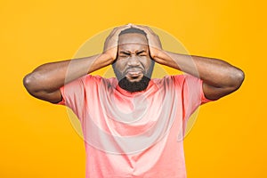 Portrait of excited young African American male screaming in shock and amazement holding hands on head. Surprised black hipster