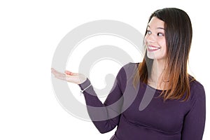 Portrait of an excited young brunette woman presenting in palm hand empty space