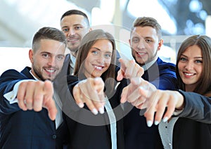 Portrait of excited young business people pointing at you