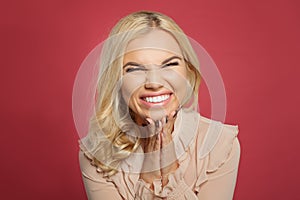 Portrait of excited young casual woman screaming on pink background