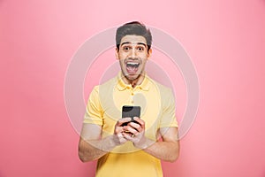 Portrait of an excited young man holding mobile phone