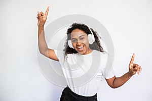 Portrait of excited young woman listening to music and dancing