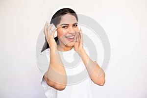 Portrait of excited young woman listening to music in headphones