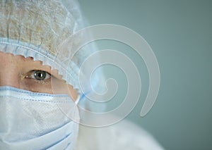 Portrait of the exhausted doctor`s half of the face in a white medical mask on the face.