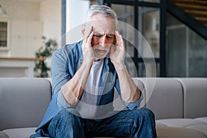 Portrait of exhausted mature man with closed eyes, suffering from headache disease