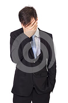 Portrait of exhausted young businessman covering his face
