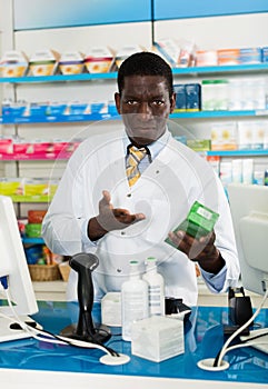 Portrait of experienced male pharmacist counseling about medicines in pharmacy