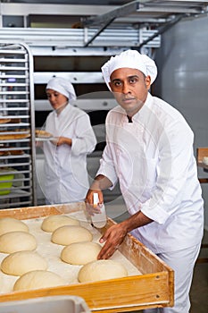 Portrait of experienced professional baker during daily work in kitchen of bakeshop