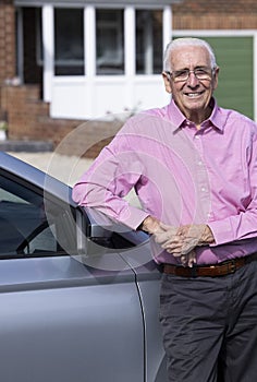 Portrait Of Experienced Senior Male Driver Standing Next To Car