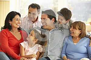 Portrait Of Extended Hispanic Family Relaxing At Home photo