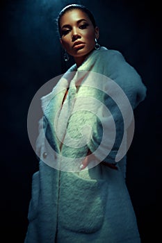Portrait of an extraordinary beautiful stylish metis young woman with perfect smooth glowing mulatto skin in a fur coat