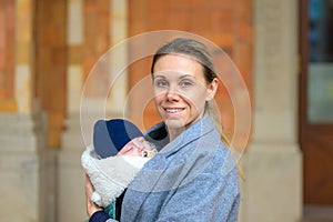 Portrait of a extreme happy late-term mother in her 40s holding her newborn baby and smiling to the camera