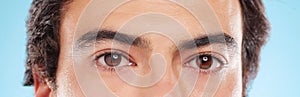 Portrait, eyes and closeup of man, vision and eyecare with microblading, eyebrow and calm for test. Blue background photo