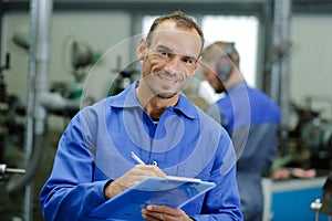 Portrait factory supervisor holding clipboard