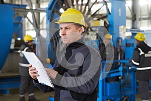 Portrait of factory worker holding paper clipboard