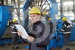 Portrait of factory worker holding paper clipboard