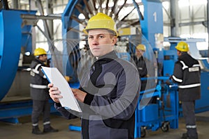 Portrait of factory worker holding paper clipboard