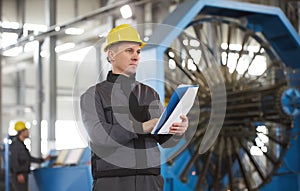 Portrait of factory worker holding paper clipboard