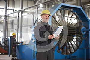 Portrait of factory worker holding paper clipboard