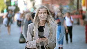 Portrait of fair natural haired business lady typing messages on mobile phone.