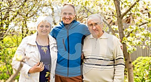 Portrait Of Family With Adult Son outdoors.