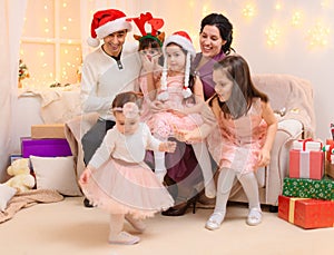 Portrait of a family celebrating new year or christmas holiday, parents and children, dressed in santa helper hat, sitting on a