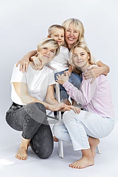 Portrait of a family of different generations. Love and tenderness. Women of different ages and a little boy hug and laugh on a