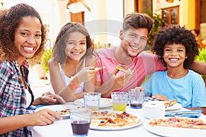 Portrait Of Family Eating Meal At Outdoor Restaurant