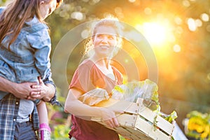 Portrait of a family of famers carrying their vegetables home in wooden boxes, at the end of the day, the Father is carrying their