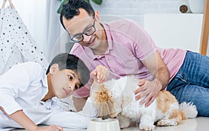 Portrait of family, father, son, dog staying together, showing love, warm expression at cozy or comfortable home. Lifestyle,