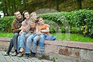 Portrait of family of four sitting in park