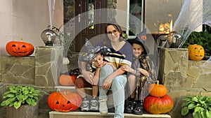 Portrait Family in Halloween Costume Smiling by Spooky Decorated Porch