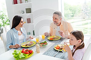 Portrait of family harmony parents chatting daughter drink juice eat healthy domestic dish modern kitchen flat indoors