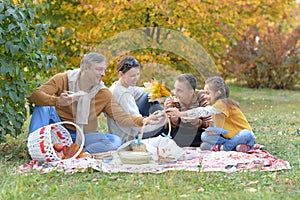 Portrait of family having a picnic in the park in autumn