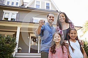 Portrait Of Family Holding Keys To New Home On Moving In Day