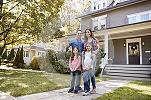 Portrait Of Family Holding Keys To New Home On Moving In Day