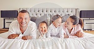 Portrait of family in home bedroom, young kids smile on bed and mother laughing with girl baby happiness. Face of happy