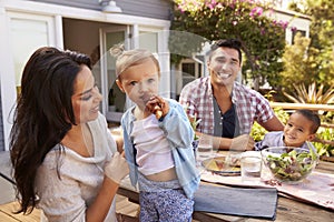 Portrait Of Family At Home Eating Outdoor Meal In Garden